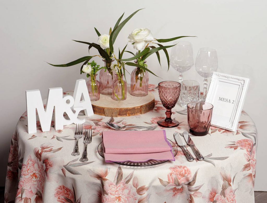 Eingedeckter Tisch mit Blumentischdecke und rosa Trinkgläsern