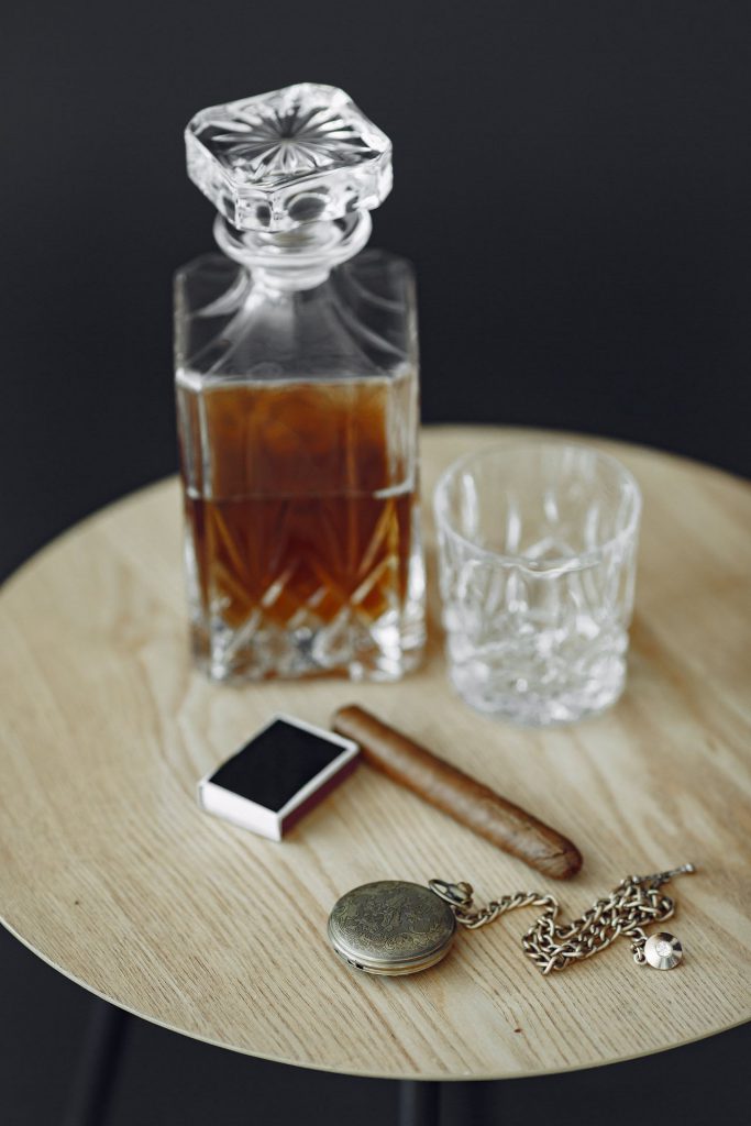 Glas Whiskey mit Zigarre auf dem Tisch